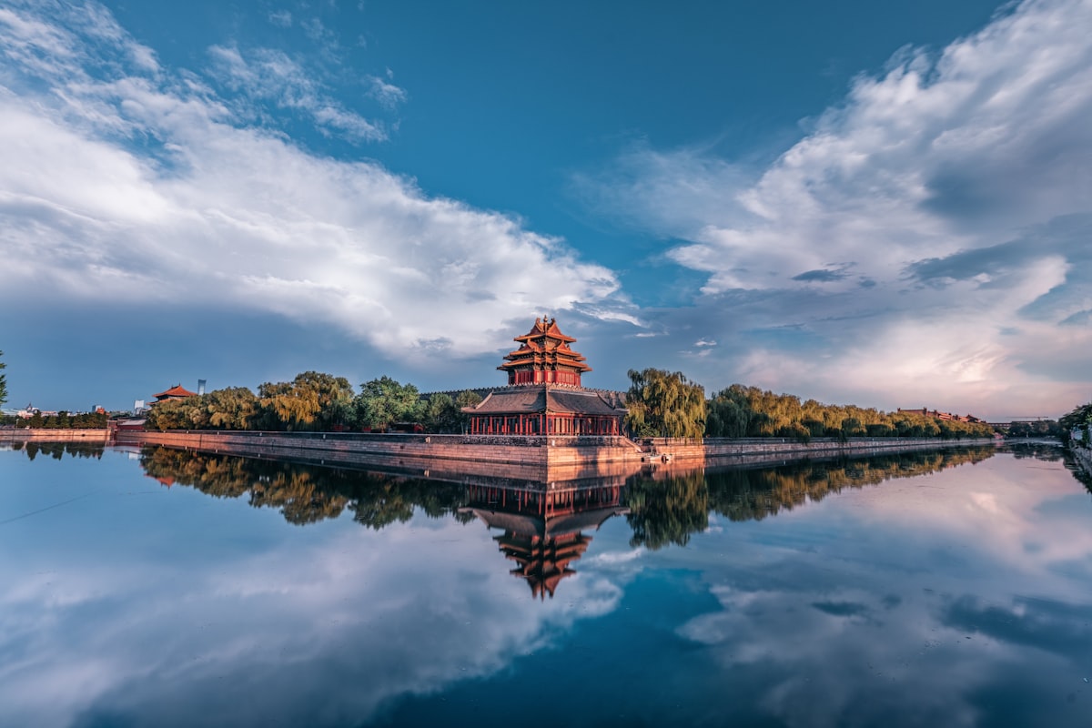 The Forbidden City corner tower reflected in the moat at sunset, Beijing