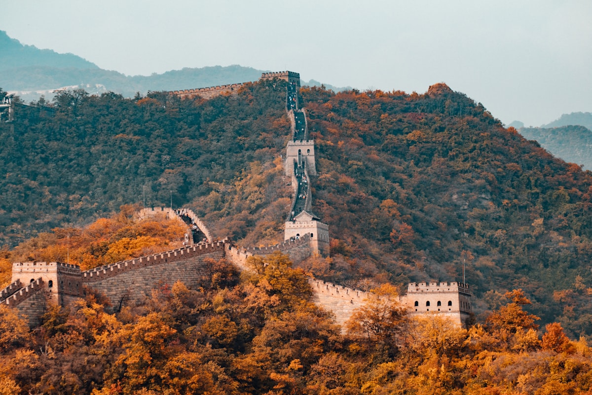 The Great Wall of China winding over forested mountains